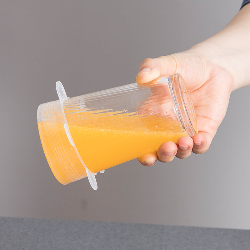 Silicone lid stretched over a glass of juice