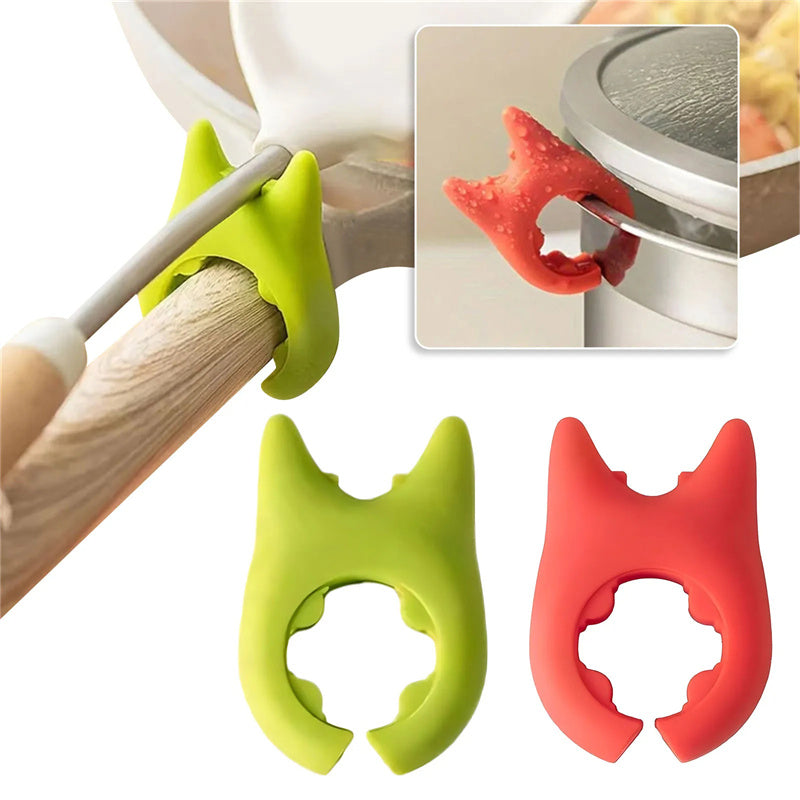 Green silicone pot clip holding a spoon on a pan handle