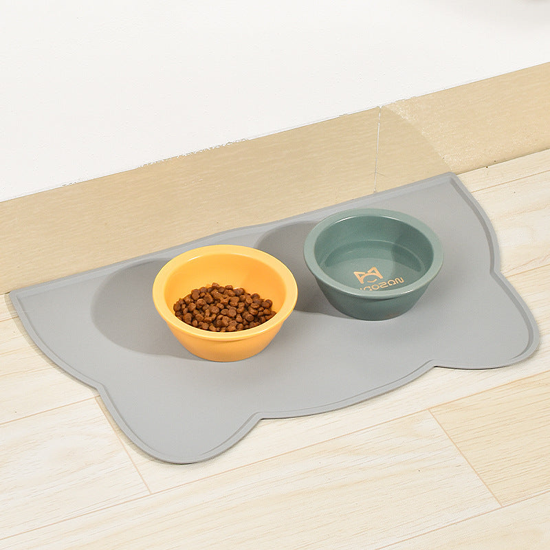 Grey cat-head silicone pet mat under two bowls