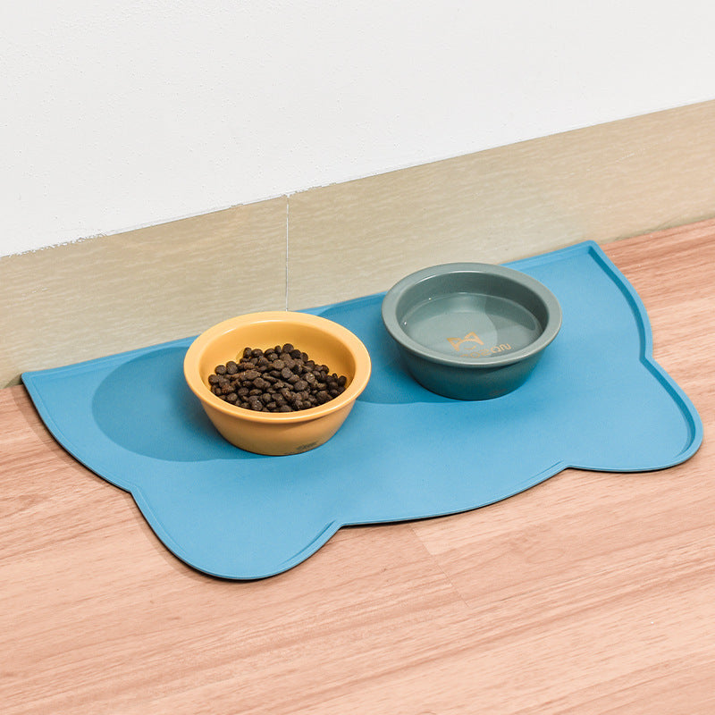 Blue cat-head silicone pet feeding mat on a wooden floor